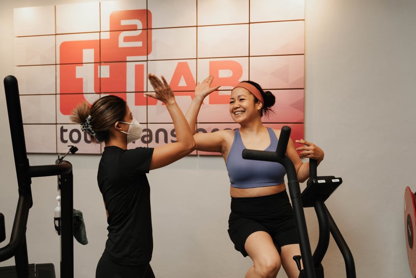 Happy Woman Giving High Five to Her Personal Trainer